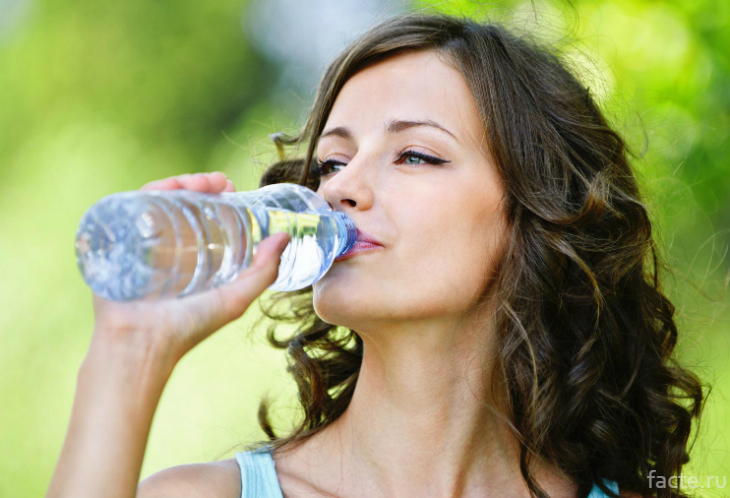 Девушка пьет воду из бутылки